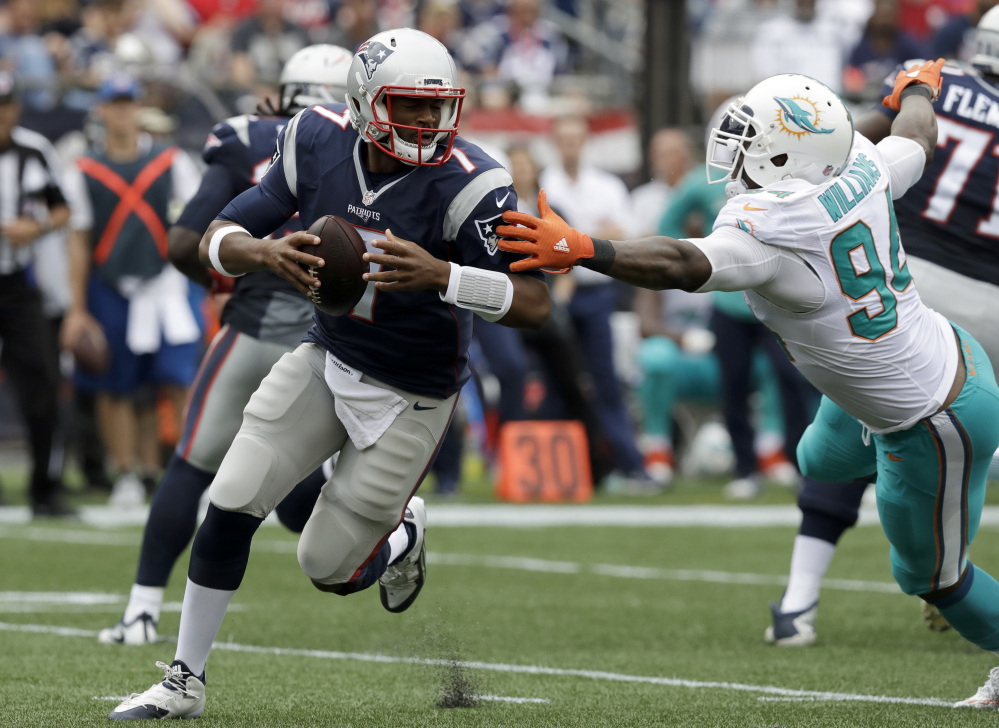New England Patriots quarterback Jacoby Brissett (7) scrambles away from Miami Dolphins defensive end Mario Williams (94) during the second half Sunday in Foxborough, Massachusetts. Two months ago, Brissett was a third-string rookie. Tonight, he could become the first African-American quarterback to start a regular-season game for the New England Patriots.