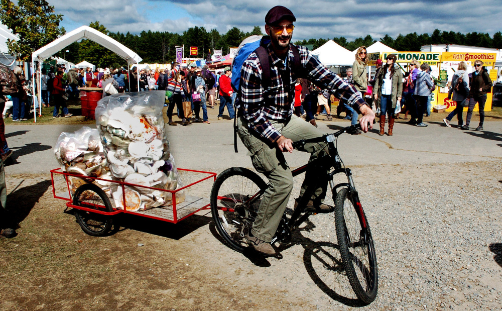 Volunteer Gregory Buzzell pedals a bike with an attached trailerload of recycling material he collected at the Common Ground Country Fair in Unity on Sunday.