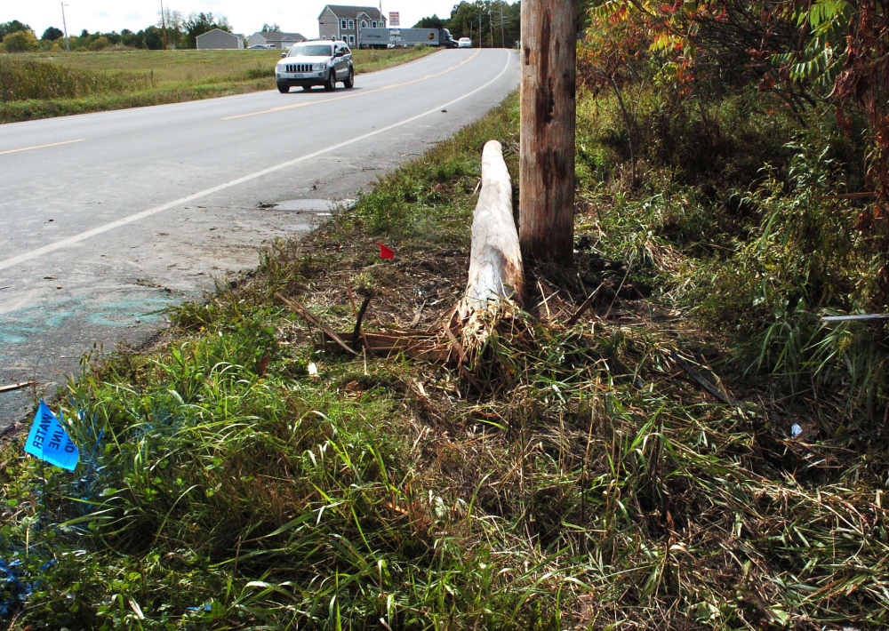 Traffic on U.S. Route 201 in Winslow passes a broken utility pole that a vehicle struck Tuesday morning, cutting power to hundreds. Witnesses say a female driver fled the crash scene on foot.