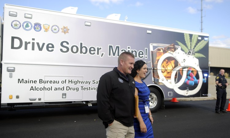 Form left, Augusta police Maj. Jared Mills,  Bureau of Highway Safety analyst Jessica Voisine and Augusta police Lt. Kevin Lully walk on Wednesday around the state's new impaired driving roadside testing vehicle, which was unveiled at the Maine Department of Public Safety in Augusta. The vehicle, which enables police to conduct sobriety tests on the road, was purchased with federal grant money for just under $300,000.