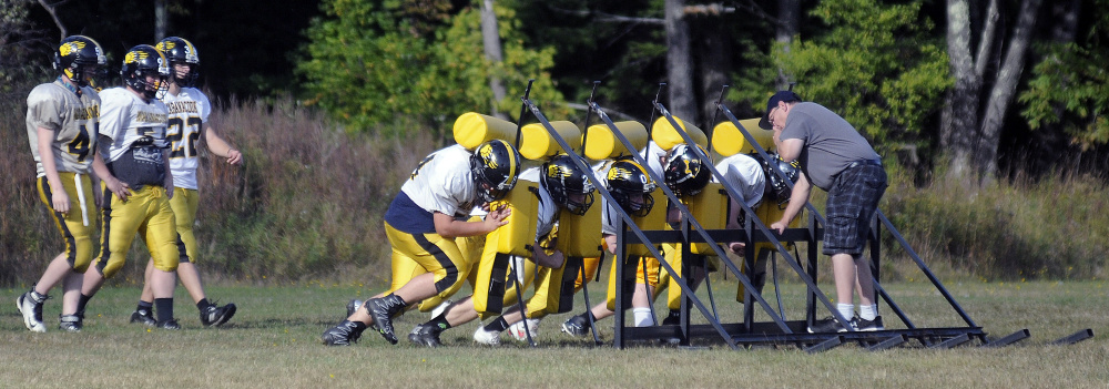 Members of the Maranacook football team hit the sled during practice Tuesday in Readfield.