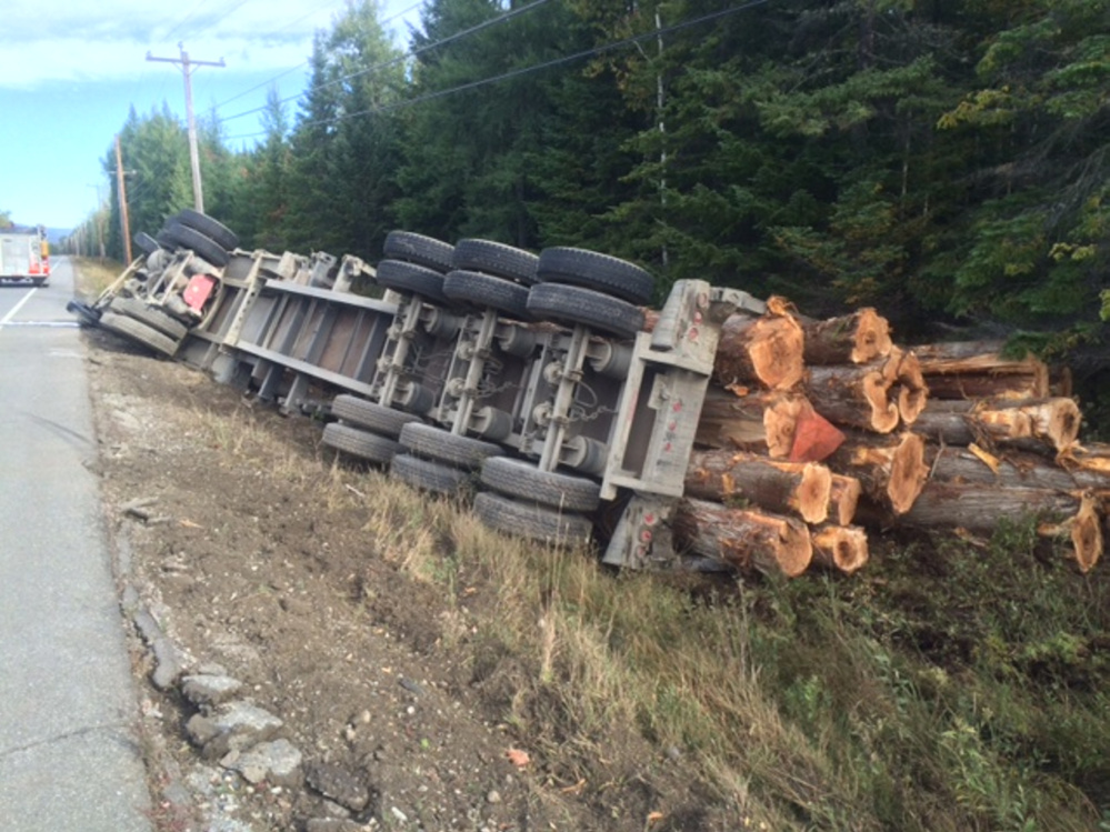 A logging truck owned by an Athens trucking company rolled over Thursday morning on U.S. Route 201 in Moose River. The driver suffered minor injuries, police said.