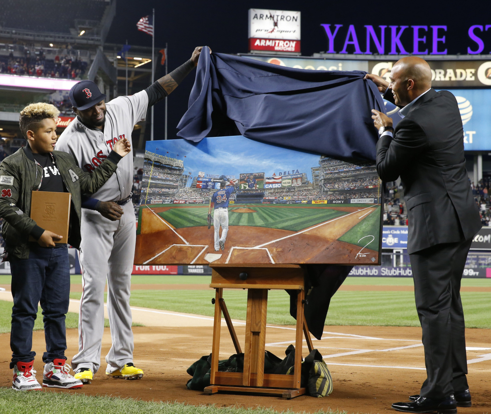 Boston Red Sox designated hitter David Ortiz, second from left, and his son D'Angelo, left, watch as retired New York Yankees relief pitcher Mariano Rivera helps unveil a painting that was given to Ortiz by the Yankees on Thursday in New York.