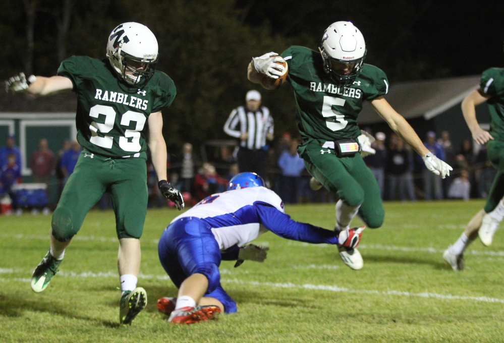 Winthrop/Monmouth's Nate Scott gets tripped up by Oak Hill High School's Austin Noble as Dylan Boynton (23) looks on during first-half action on Friday night in Winthrop.