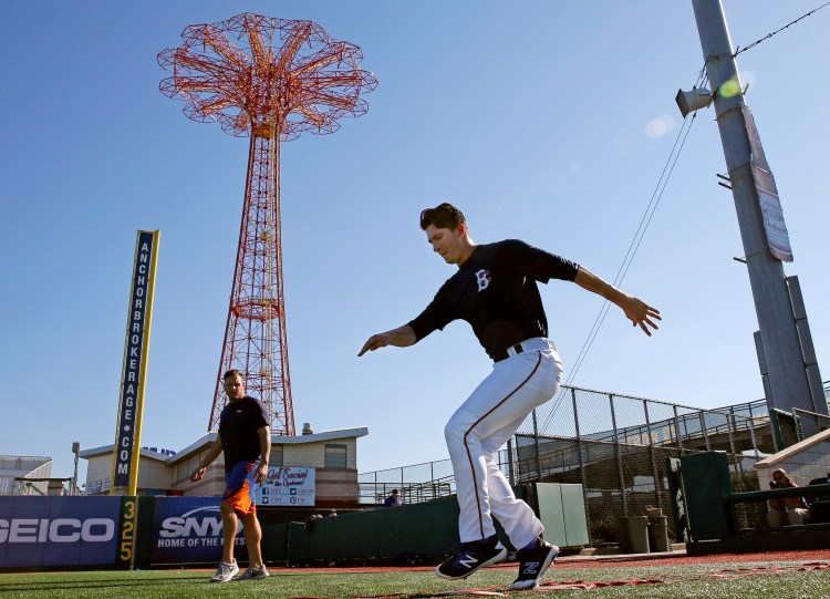 Brooklyn Cyclones strength coach Joe Lego watches pitcher Gary Cornish perform agility drills in the shadow of Coney Island amusement park.  Known for long bus rides between often picturesque ballparks, the minor leagues are hamlets of hope populated by a few bonus babies and thousands of conventional kids trying to grind their way up the pecking order to the sport's highest level.    Associated Press/Kathy Willens