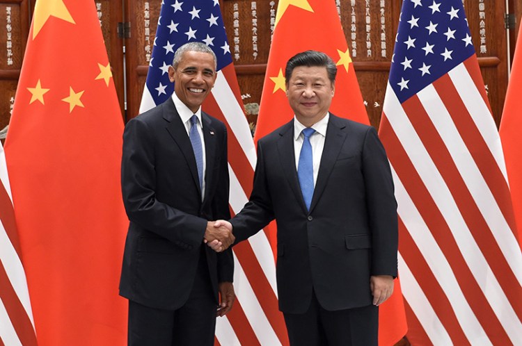 Presidents Obama and Xi Jinping pose for photographers as they shake hands before their meeting in Hangzhou.
