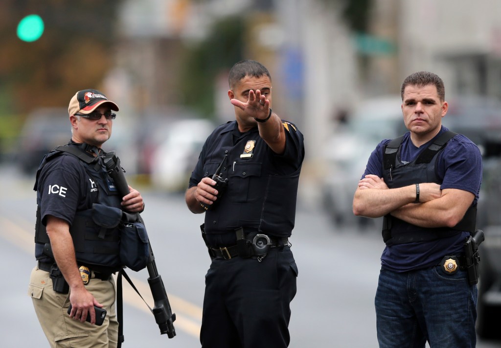 Police officers stand on Elizabeth Ave.,  in Linden, N.J., near where an Afghan immigrant wanted for questioning in the bombings that rocked a New York City neighborhood and a New Jersey shore town was taken into custody after being wounded in a shootout with police, authorities said, Monday in Linden.