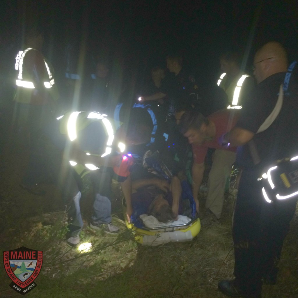 Rescuers tend to an old man with dementia who got lost in the woods in Camden on Tuesday night. (Courtesy Maine Game Wardens)