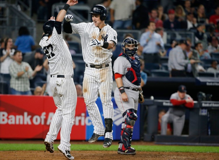 New York's Austin Romine, left, celebrates with Tyler Austin after scoring on Austin's seventh-inning, two-run home run off Red Sox starting pitcher David Price.   Associated Press/Kathy Willens
