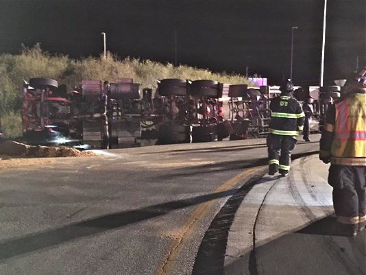 A tractor-trailer tanker truck carrying fuel lies on its side at a rotary in Gorham Thursday night. <em>WCSH photo</em>