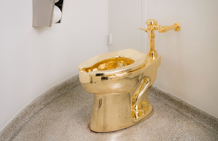 A fully functioning 18-karat gold toilet awaits the adventurous in the Guggenheim Museum's 14th-floor restroom. It's part of Italian artist Maurizio Cattelan 's "America" exhibit. <em>Kristopher McKay/Solomon R. Guggenheim Museum via AP</em>