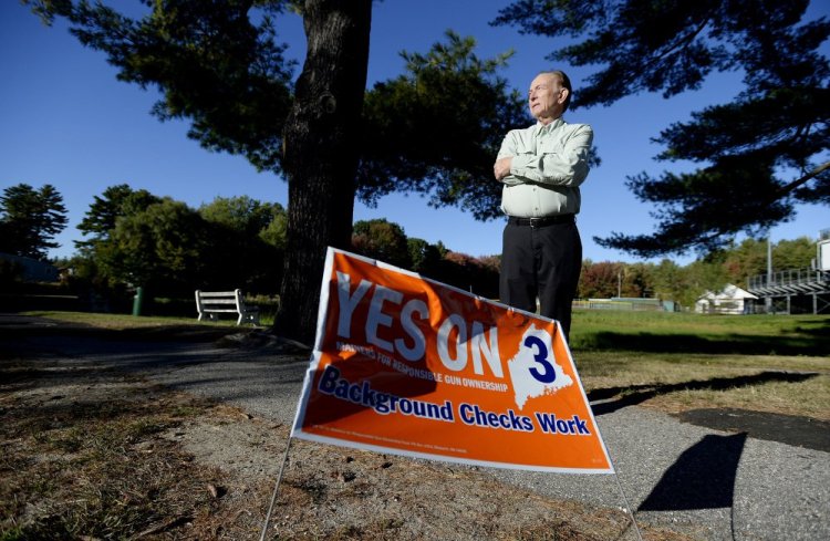 Bradley Ronco of Portland, who says many of the "Yes on 3" signs in his neighborhood have been knocked down or stolen, stands Wednesday near one of the remaining signs, on Ludlow Street.
