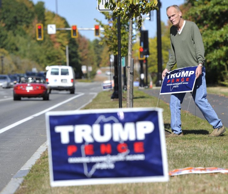 John Moon plants political signs along a Route 1 right-of-way in Falmouth on Thursday, as a favor to a friend. But merchants along the business corridor worry about the effect on customers.
