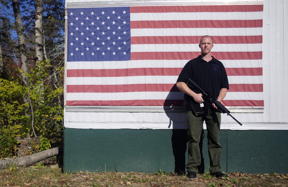 Tim Hendsbee stands with a Windham Weaponry SRC 7.62x39 outside of his small gun shop, HF Firearms, next to his home in Levant.
