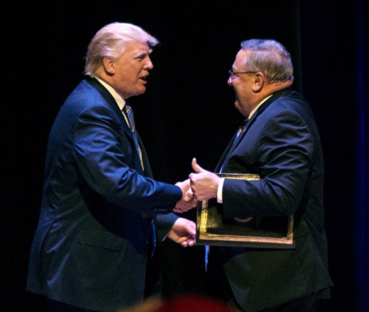 Gov. Paul LePage welcomes Donald Trump at a rally Aug. 4 in Portland. LePage said Tuesday that a 2005 video containing lewd comments by Trump is "ancient history."