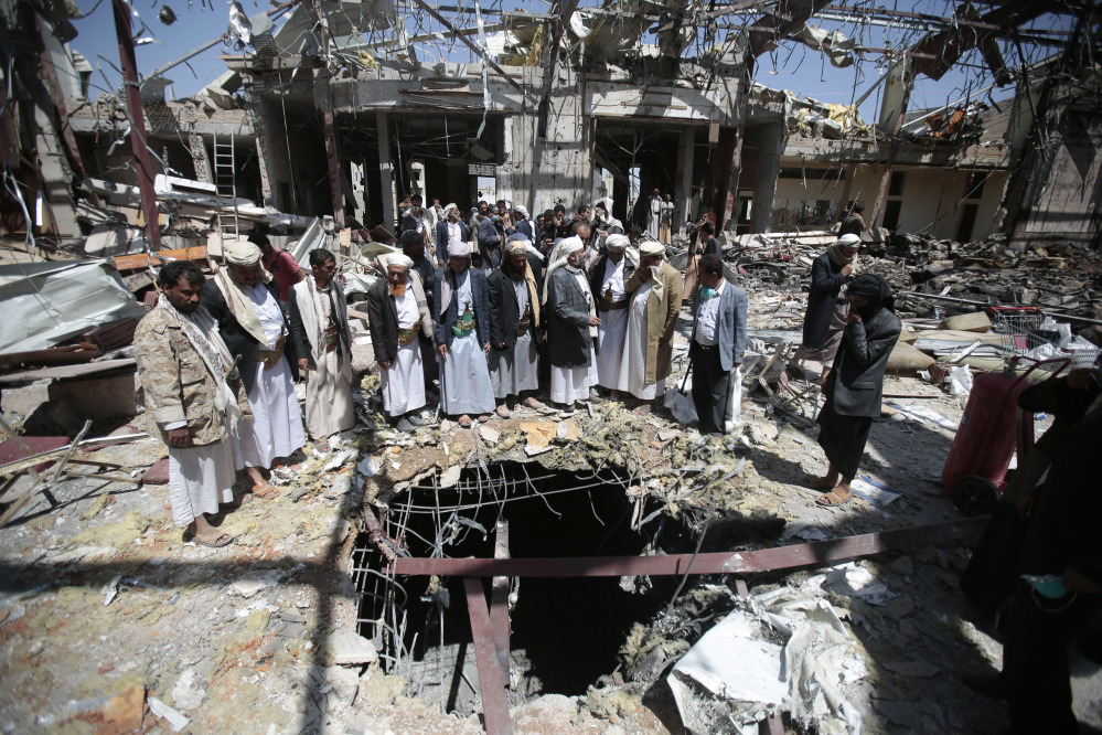 Members of the Higher Council for Civilian Community Organization inspect a destroyed funeral hall Thursday as they protest against a deadly Saudi-led airstrike on a funeral hall in Sanaa, Yemen. The attack led to missiles being fired at U.S. warships, which responded by destroying three coastal radar sites.
