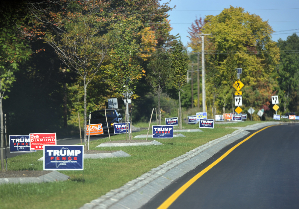 Political signs line a road in Falmouth on Thursday. Gov. Paul LePage asked the Maine Department of Transportation to notify campaigns if their signs violate a new law that requires signs be 30 feet apart and no bigger than 4 feet-by-8 feet.
