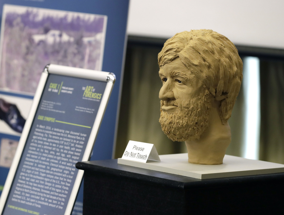 A clay bust and details surrounding an unidentified victim in a Florida cold case file is shown during the the Art of Forensics conference at the University of South Florida in Tampa.