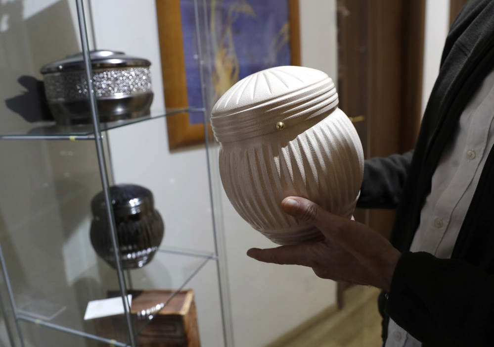 A man holds an urn at a funeral parlor in Rome on Tuesday, when the Vatican published guidelines for Catholics who want to be cremated, saying their remains cannot be scattered, divvied up or kept at home but rather stored in a sacred, church-approved place.
