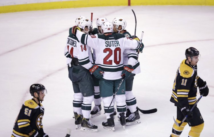 Minnesota right wing Jason Pominville is surrounded by teammates after scoring a third-period goal in the Wild's 5-0 shutout of the Bruins on Tuesday night in Boston.