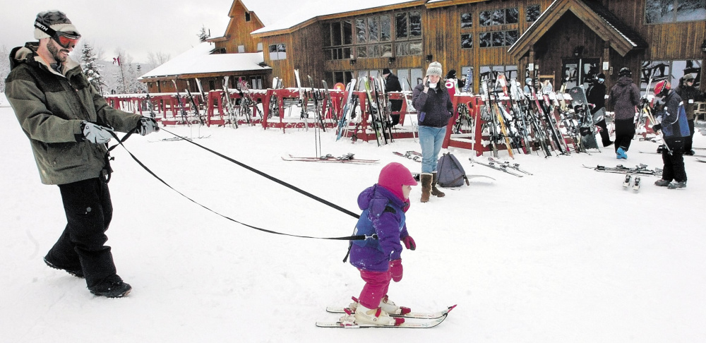 Staff file photo by David Leaming 
 MUSH: Gabbie Archibald is held by a tether line by her father Ian while skiing for the first time near the renovated baselodge at Saddleback Mtn. ski resort near Rangeley.
