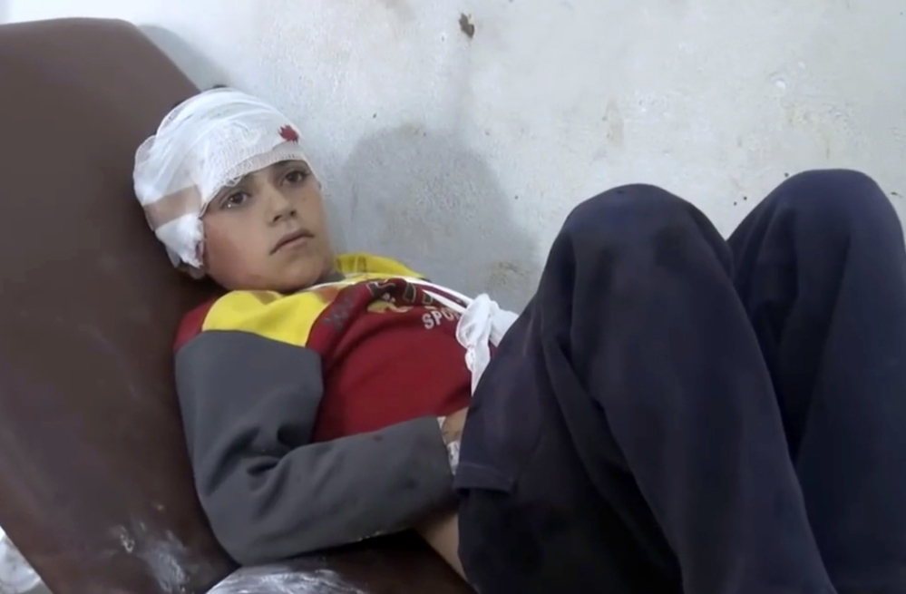 A hospitalized child is one of 50 people wounded in airstrikes on a Syrian school that some say constitute a war crime.