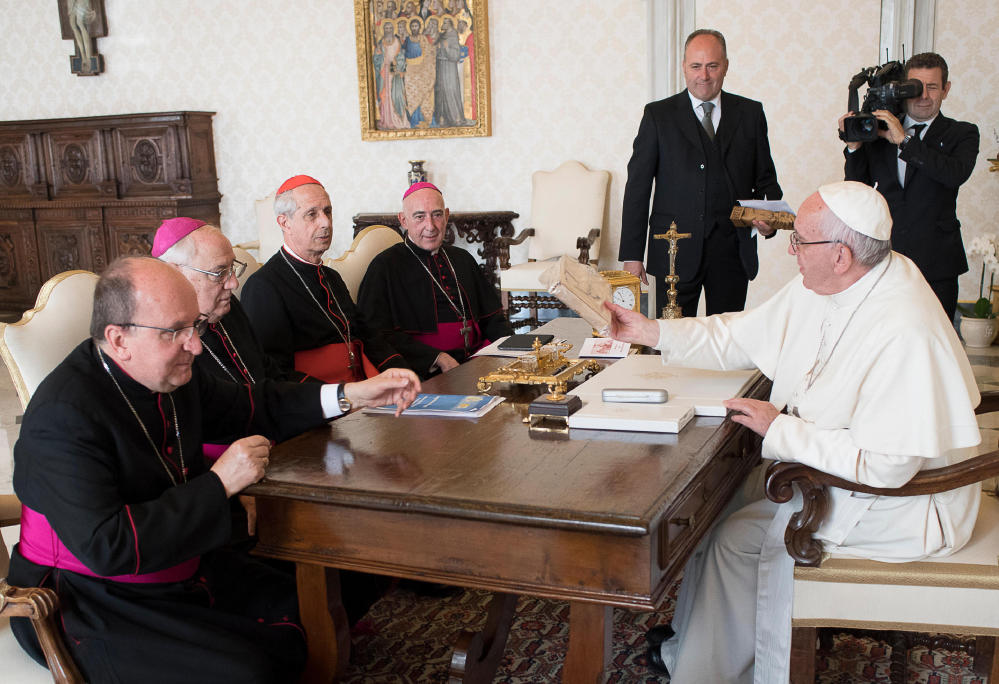 FILE - In this Oct. 17, 2016 file photo, Pope Francis sits at a table with, from left; Mons. Mario Antonio Cargnello, Archbishop Jose Maria Arancedo, Cardinal Mario Poli, and Mons. Carlos Humberto Malfa, on the occasion of his meeting with the Argentine Episcopal Conference,at the Vatican. The Vatican and Argentina's Catholic Church said Tuesday, Oct. 25, 2016, they had finished cataloguing their archives from the country's brutal "dirty war" and will soon make them available to victims and their relatives who have long accused the church of complicity with the military dictatorship.  (L'Osservatore Romano/Pool Photo via AP, files)