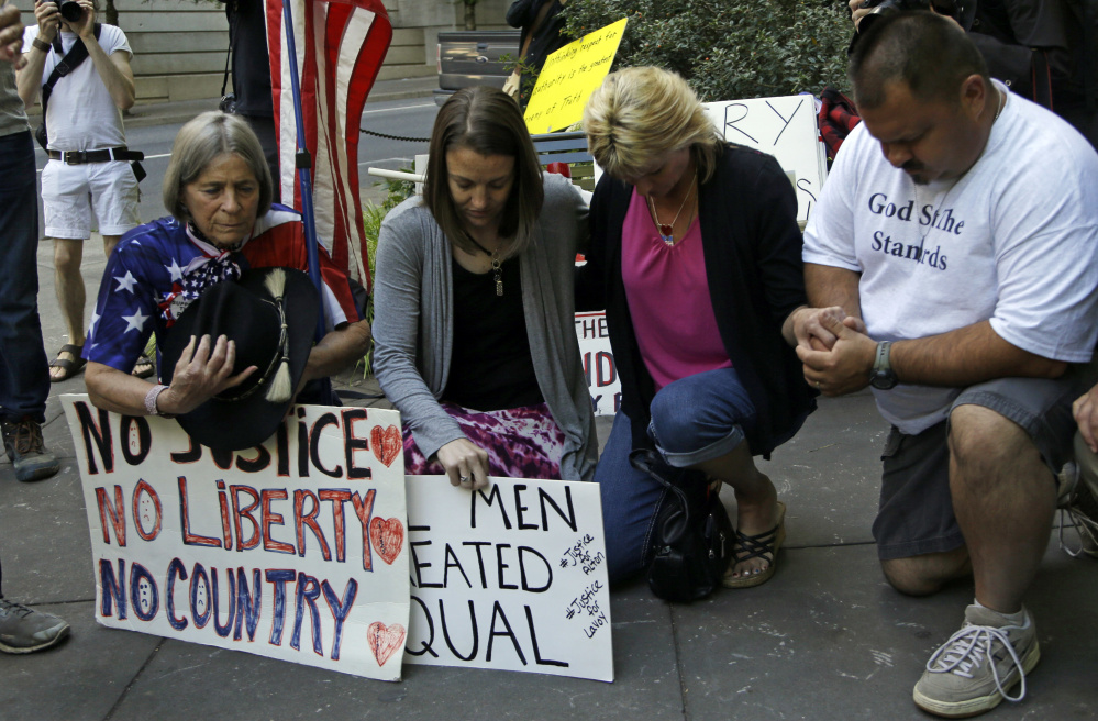 Protestors kneel in prayer outside federal court in Portland, Ore., Sept. 13 as the trial of the Bundy brothers, Ammon and Ryan, and five others gets underway.