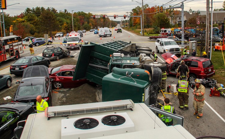 Emergency personnel work at the scene of a 10-vehicle accident Thursday in York. The accident happened when a dump truck filled with gravel tipped onto its side.
AJ St. Hilaire/Portsmouth Herald via AP