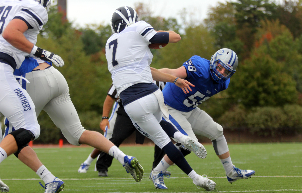 Middlebury College quarterback Jared Lebowitz eludes a tackle by Colby College's Ben Hartford during first-half action Saturday in Waterville.