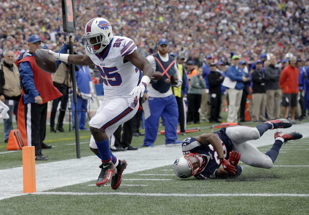Buffalo Bills running back LeSean McCoy (25) leaves New England Patriots cornerback Malcolm Butler, right, tumbling as he crosses the goal line for a touchdown Sunday in Foxborough, Massachusetts.
