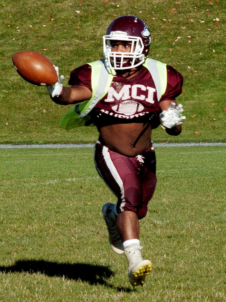 MCI senior running back Willie Moss laterals a pass to Adam Bertrand during practice in Pittsfield on Wednesday.