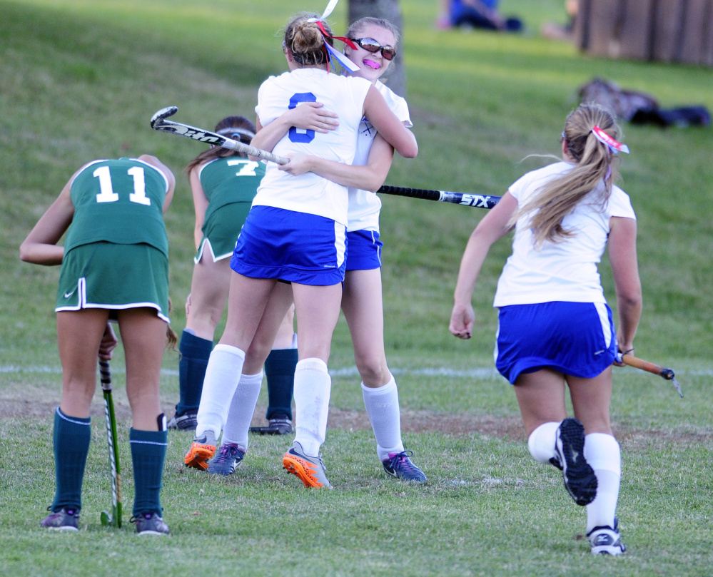 Oak Hill's Zoe Buteau, center back to camera, is hugged by teammate Hayden Spencer after scoring the game-winning goal in a 2-1 double overtime victory over Winthrop at the Carrie Ricker School in Litchfield. Kiera Young is at right.
