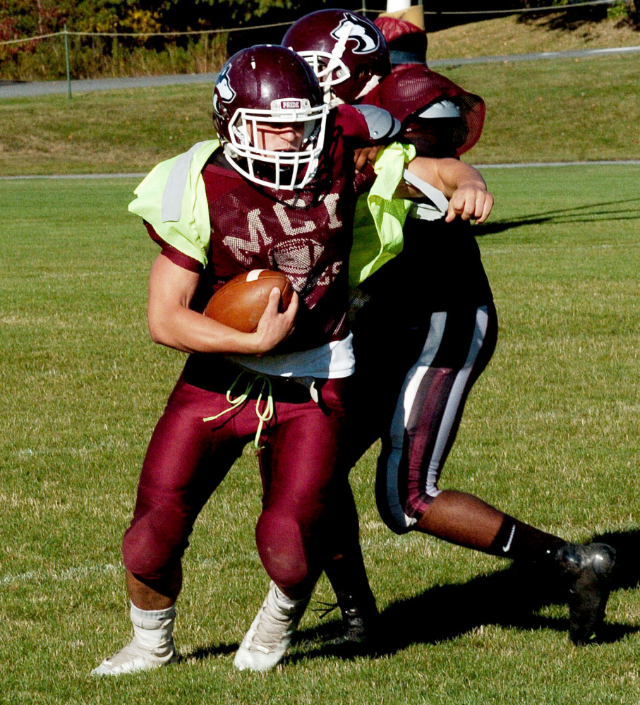 MCI running back Adam Bertrand evades a tackle during practice in Pittsfield on Wednesday.
