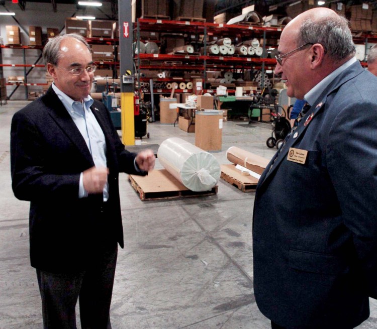 U.S. Rep. Bruce Poliquin, R-2nd District, left, speaks with Tim Gallant during a press conference at Auburn Manufacturing on Aug. 30.