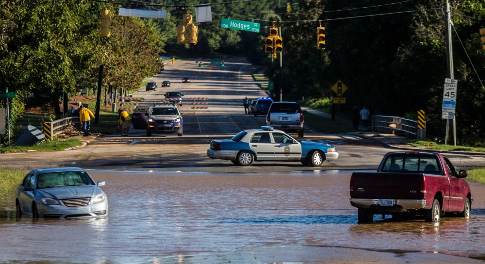 Abandoned cars sit in flood waters on Atlantic Avenue near Crabtree Creek in Raleigh, N.C., after Hurricane Matthew caused downed trees and flooding Sunday, Oct. 9, 2016. Hurricane Matthew's torrential rains triggered severe flooding in North Carolina on Sunday as the deteriorating storm made its exit to the sea, and thousands of people had to be rescued from their homes and cars. (Travis Long/The News & Observer via AP)