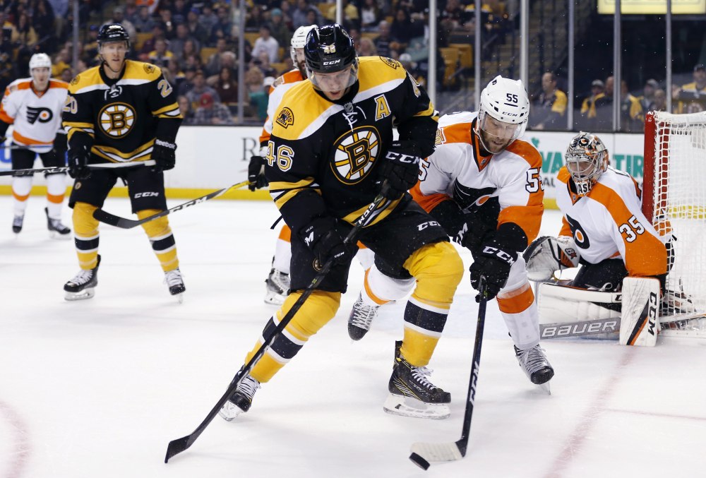 Boston Bruins forward David Krejci (46) and Philadelphia's Nick Schultz battle for the puck during the second period of a preseason game in Boston on Satruday.