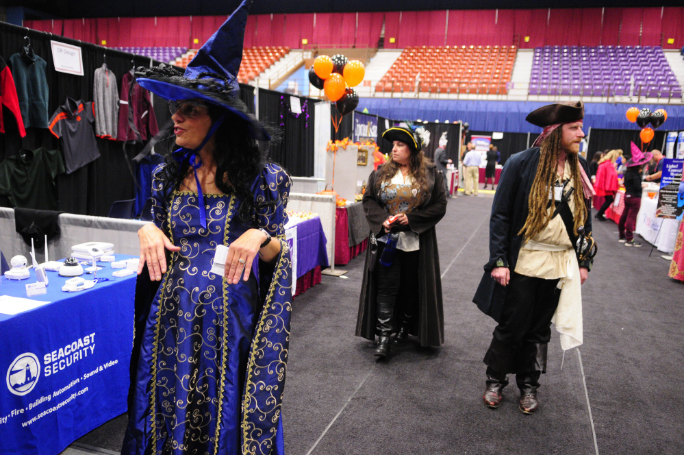 People wearing Halloween costumes while working at Kennebec Valley Chamber of Commercer EXPO booths take a break Wednesday and walk around checking out the rest of the show at Augusta Civic Center.