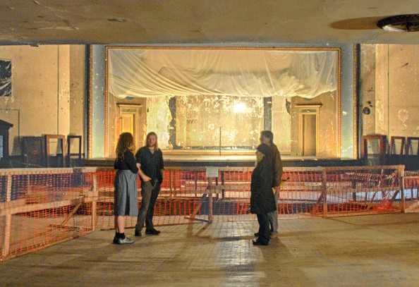 People chat in front of the stage May 13 in the Colonial Theater during the Raw Spaces: Art Walk, one of the events held to showcase the downtown Augusta theater, which some hope to revitalize.