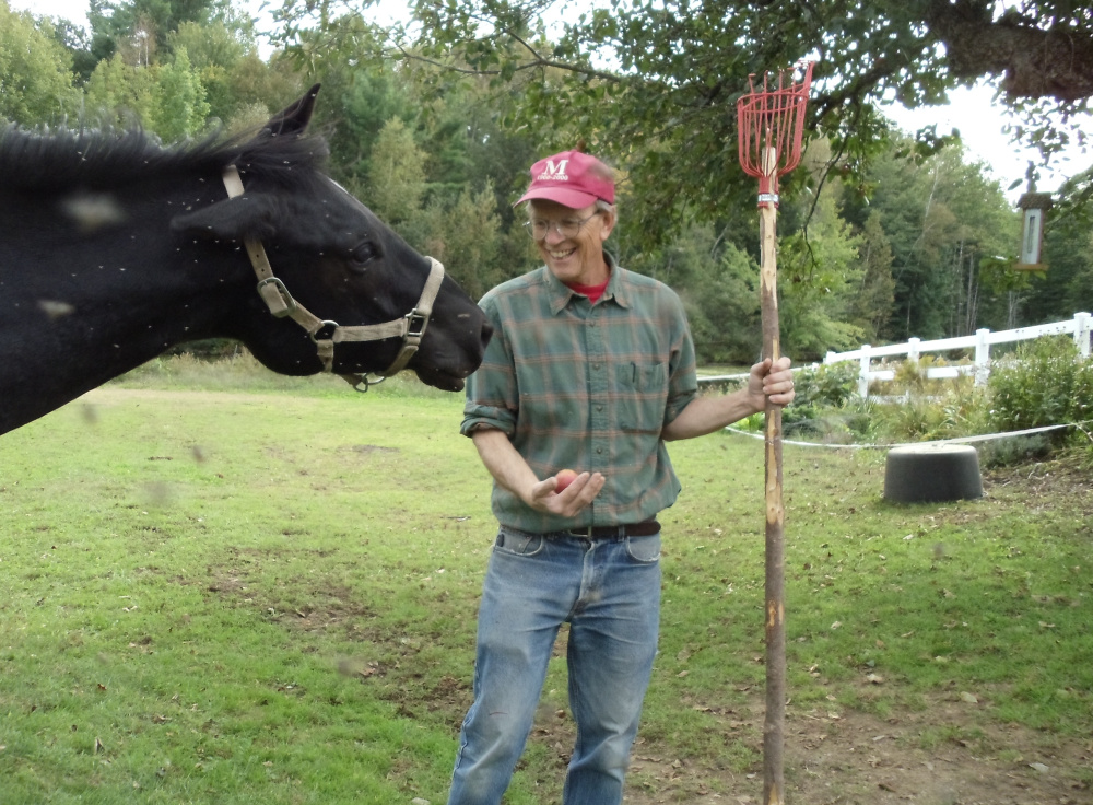 John Bunker shares an apple with his horse on his farm in Unity. Bunker, Maine's apple expert, will present a program Thursday, Nov. 10, at the Leeds Town Offfice.