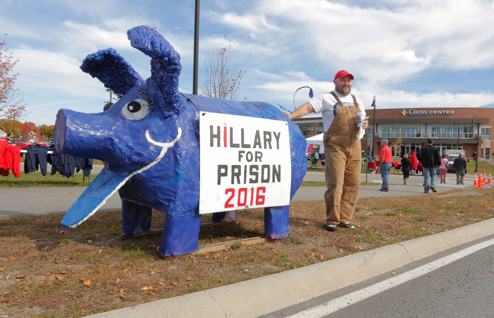 Gary Cromwell of Mercer poses for a photo with a pig sporting a Hillary for Prison 2016 sign outside the Cross Insurance Arena in Bangor on Saturday.