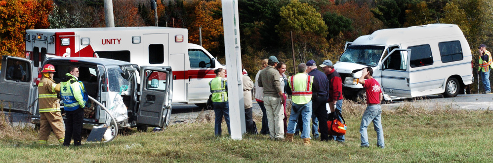 Police and firefighters investigate the scene where two vans collided at the intersection of Route 220 and the Crosby Brook Road in Thorndike on Sunday. Trooper Bethany Robinson said the van at left had nine people from the College of the Atlantic and turned into the path of the van at right.