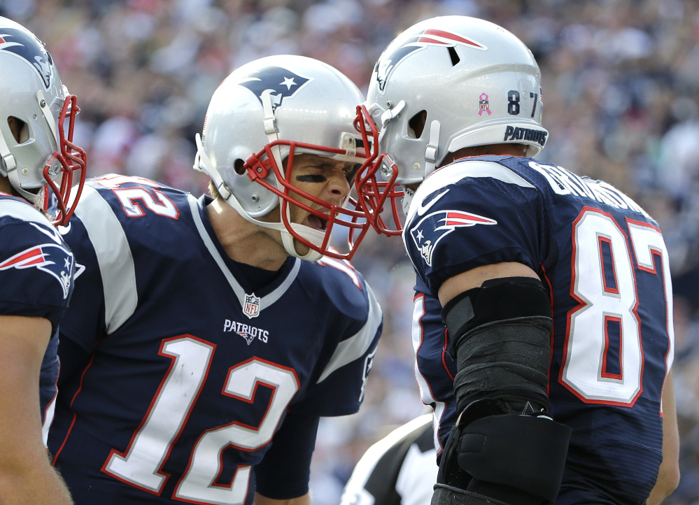 New England Patriots quarterback Tom Brady (12) celebrates his touchdown pass to tight end Rob Gronkowski (87) during the second half against the Cincinnati Bengals on Sunday in Foxborough, Massachusetts.