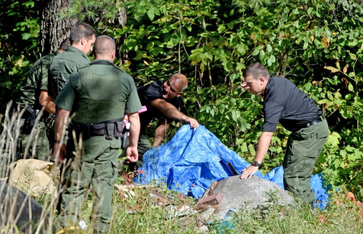 Investigators with the Maine State Police and Maine Warden's Service look for evidence in the death of Valerie Tieman, whose body was found in the woods behind 628 Norridgewock Road in Fairfield on Sept. 20.