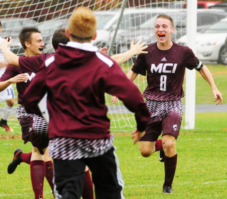 Teammates run to celebrate with Devon Varney after he scored the game-winning goal against Erskine in overtime of a Class B North preliminary game Saturday in South China.