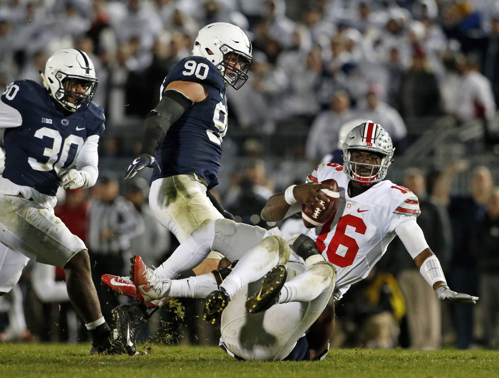 Ohio State quarterback J.T. Barrett (16) is sacked by Penn State's Jason Cabinda, behind, during the second half Saturday in State College, Pennsylvania. Penn State won 24-21.