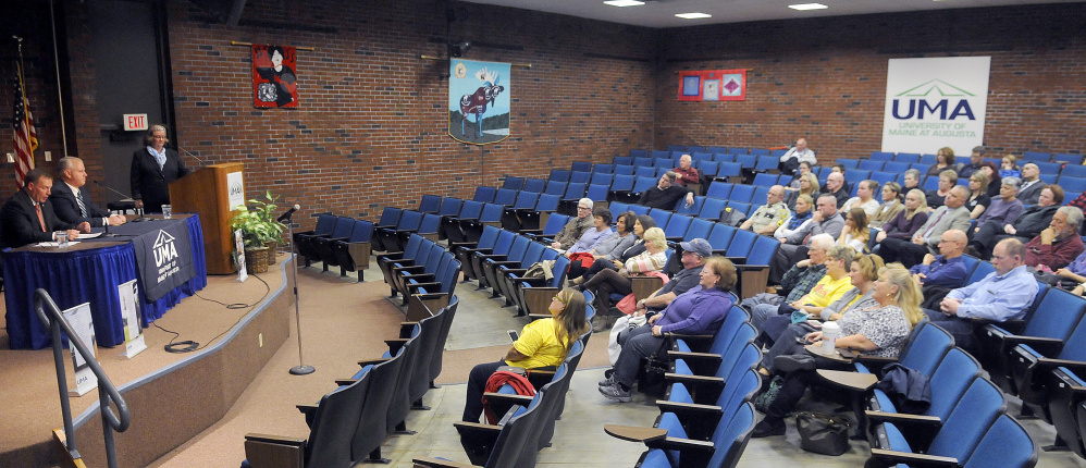 People listen to a debate between Ken Mason, left, and Ryan Reardon, center, on Monday in Augusta.