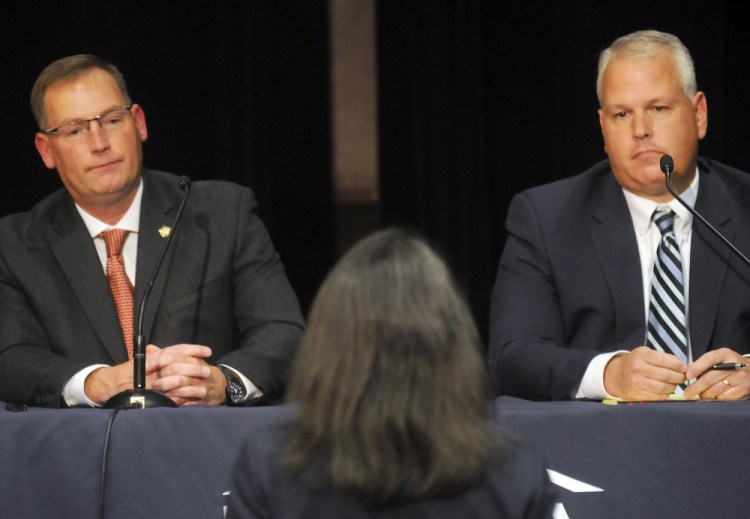 Ken Mason, left, and Ryan Reardon listen Monday to a question from District Attorney Maeghan Maloney during the debate for sheriff held in Augusta.