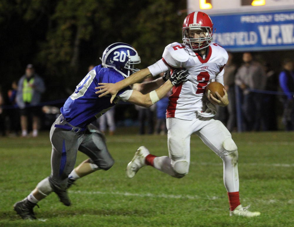 Cony High School quarterback Taylor Heath tries to break a tackle by Lawrence High School's Devon Webb during the first half of a game in Fairfield last month.