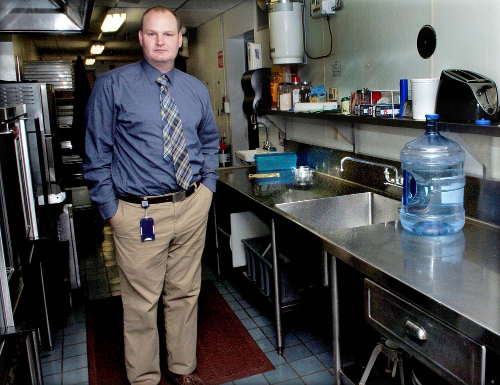 Benton Elementary School Principal Brian Wedge stands on Tuesday beside the school cafeteria kitchen sink, where high levels of lead were detected last week.